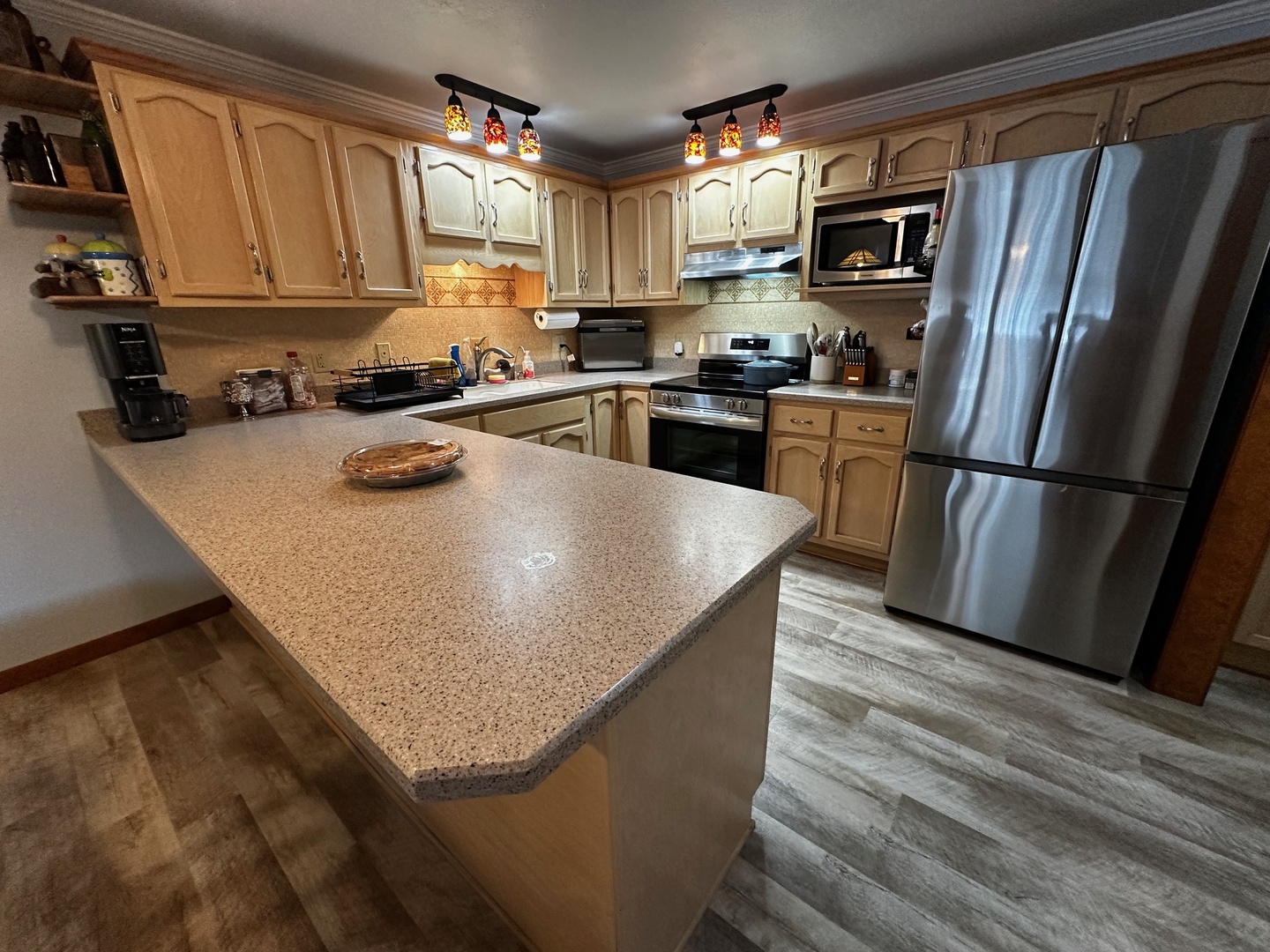 4100 416 North Clinton, IL 61727 - Photo 13 of 33 a kitchen with stainless steel appliances granite countertop a refrigerator a stove a sink dishwasher and a microwave oven with wooden floor