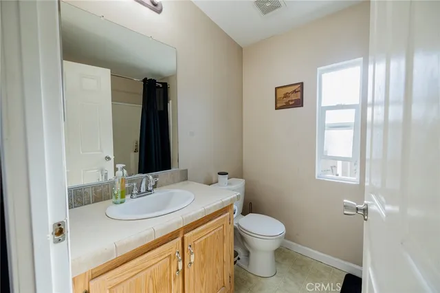 a bathroom with a granite countertop sink toilet and mirror