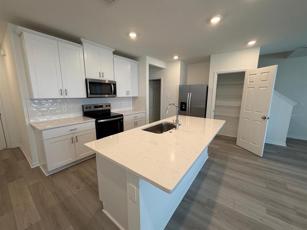 4264 Ranch House Road St. Cloud, FL 34772 - Photo 4 of 34 a kitchen with stainless steel appliances a refrigerator sink and microwave