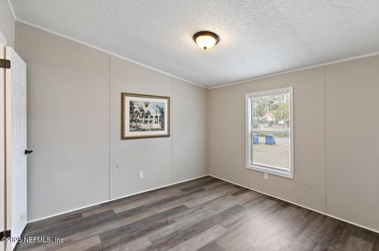 3032 Snell Street Jacksonville, FL 32218 - Photo 7 of 17 an empty room with wooden floor and windows
