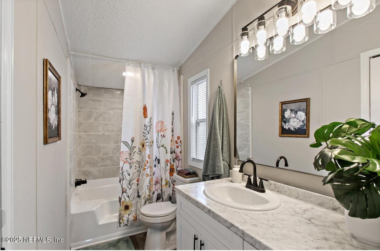 3032 Snell Street Jacksonville, FL 32218 - Photo 8 of 17 a bathroom with a granite countertop sink a toilet and shower