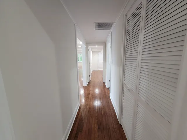 a view of a hallway with wooden floor