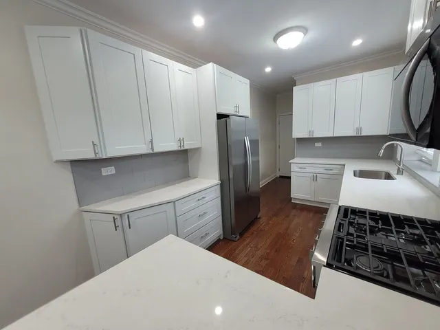 a kitchen with stainless steel appliances a refrigerator a stove a sink and a stove