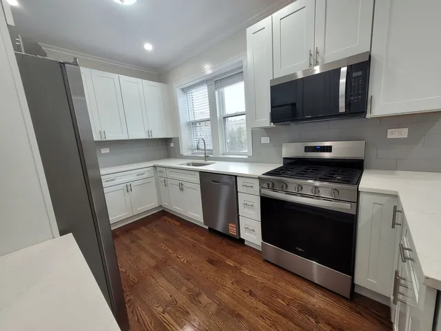 a kitchen with stainless steel appliances a stove a microwave a sink and cabinets
