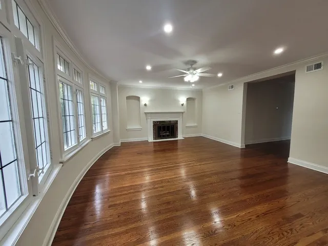 an empty room with wooden floor and fireplace