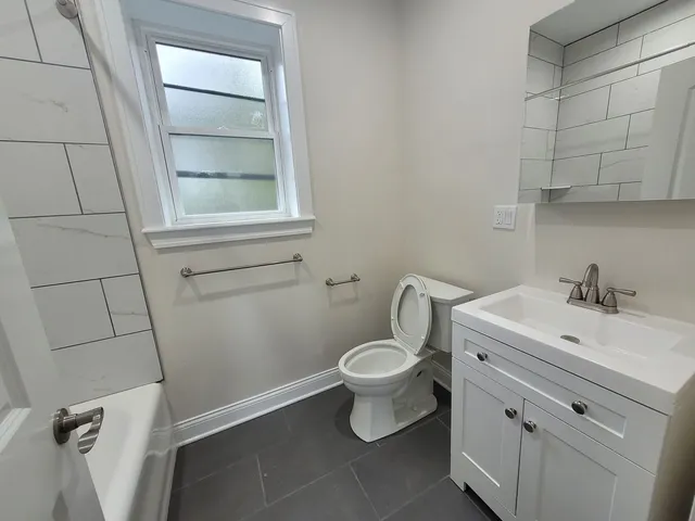 a bathroom with a sink toilet and window