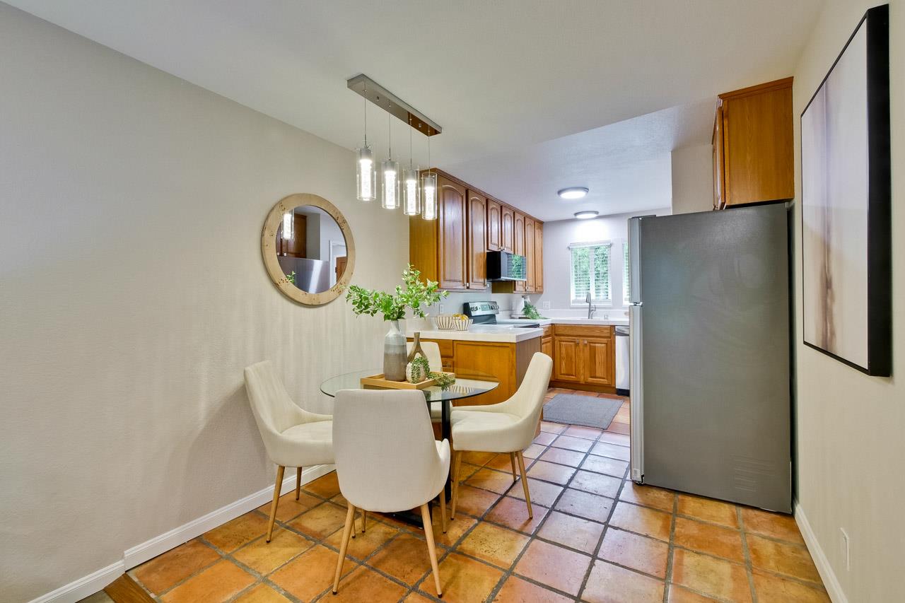 1046 Wright Avenue, Unit J Mountain View, CA 94043 - Photo 8 of 36 a living room with a dining table and a clock