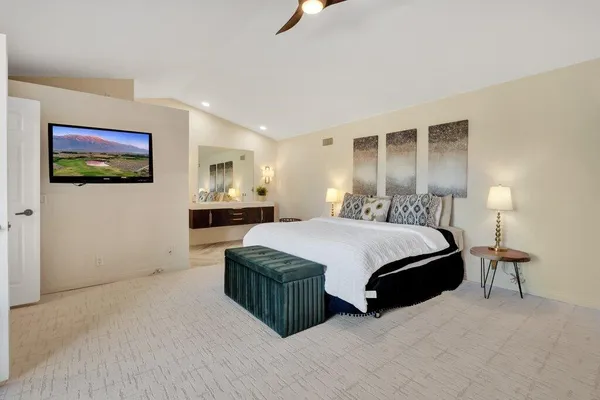 a spacious bedroom with a bed and painting on the wall