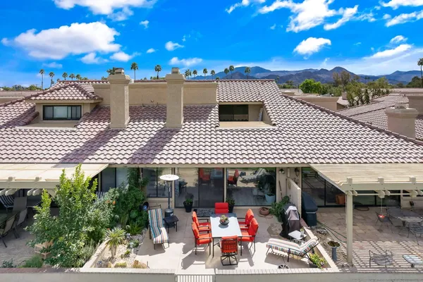 a view of a patio with dining table and chairs under an umbrella with a fire pit