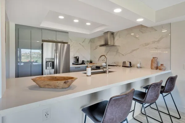 a large kitchen with a large window and stainless steel appliances