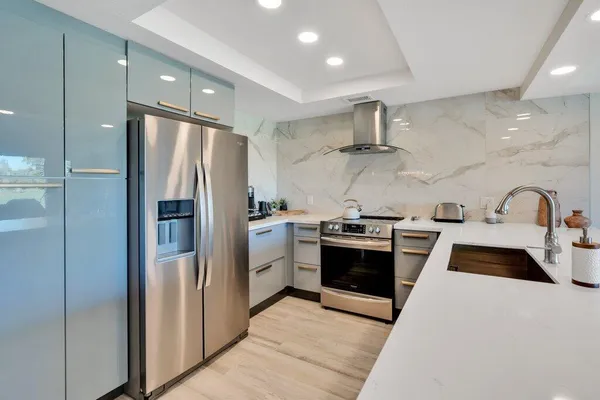 a kitchen with stainless steel appliances granite countertop a refrigerator and a sink