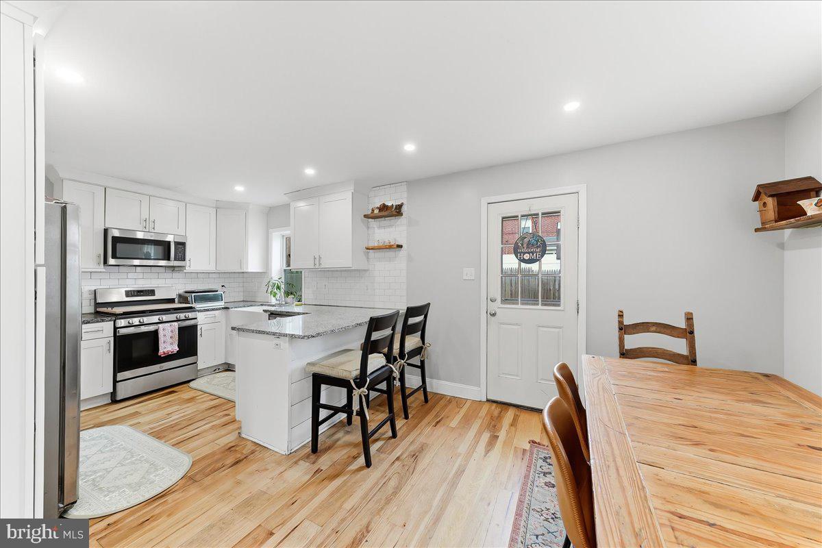 601 Willowbrook Road Havertown, PA 19083 - Photo 5 of 25 a kitchen with stainless steel appliances a stove a sink a refrigerator with white cabinets and wooden floor
