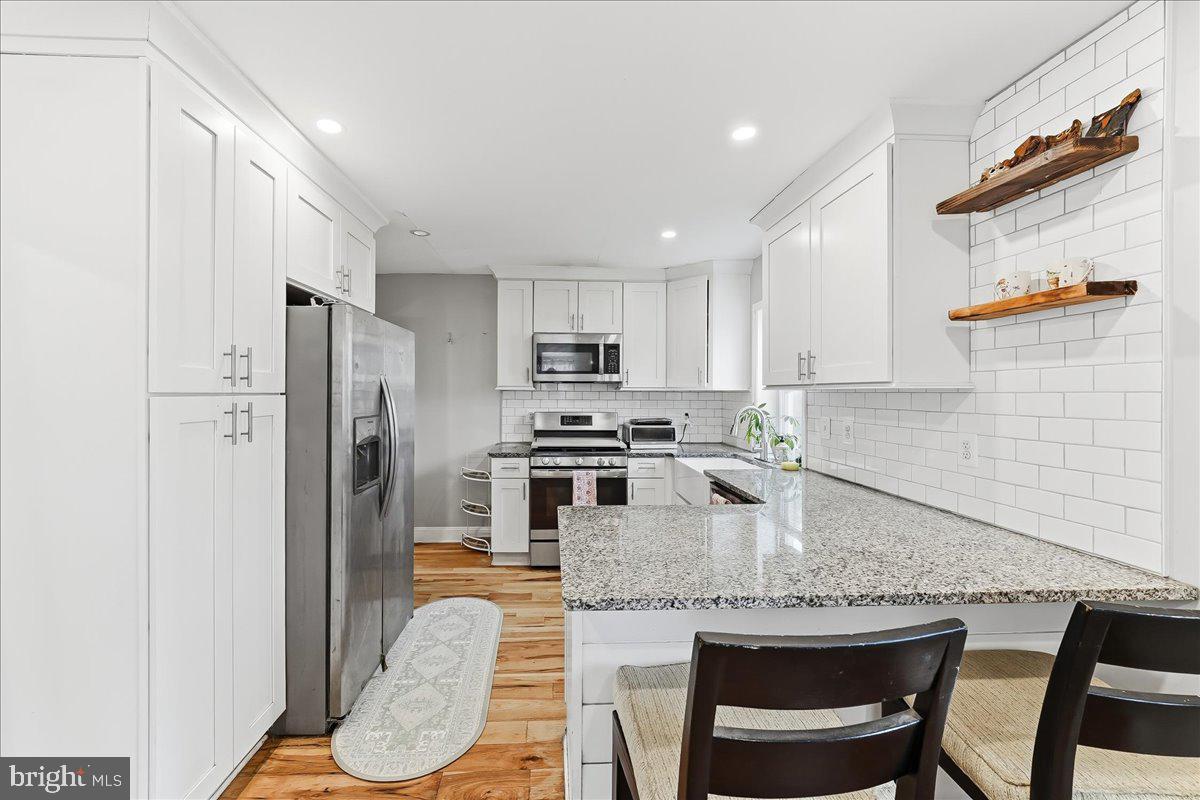 601 Willowbrook Road Havertown, PA 19083 - Photo 9 of 25 a kitchen with stainless steel appliances granite countertop a stove a refrigerator a sink a dining table and chairs