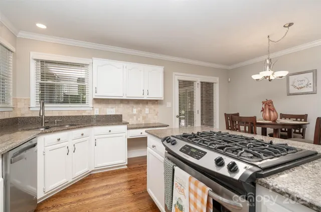 a kitchen with a stove a sink and a window