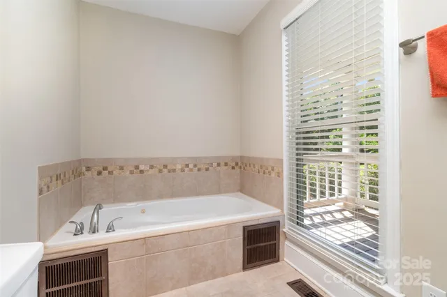 a bathroom with bathtub and window