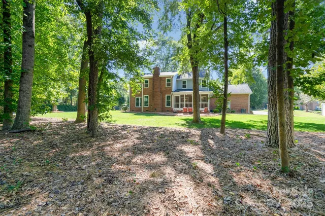 a view of a house with backyard and a tree