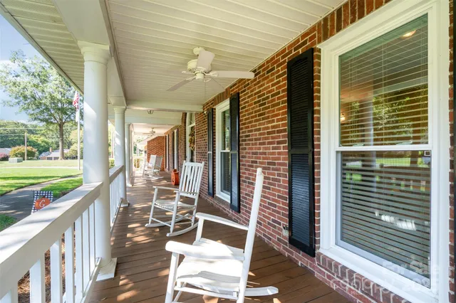 a view of a porch with wooden floor next to a yard