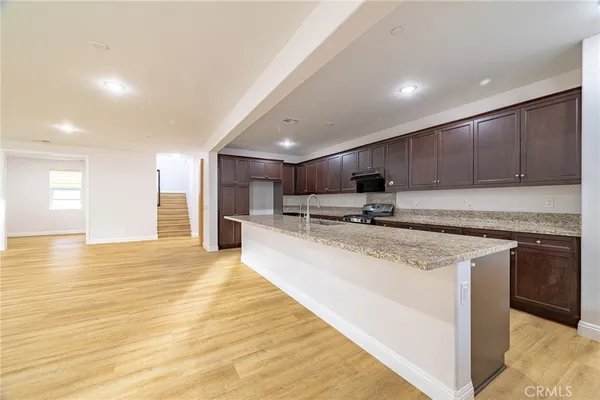 a large kitchen with stainless steel appliances granite countertop a stove a sink and a refrigerator