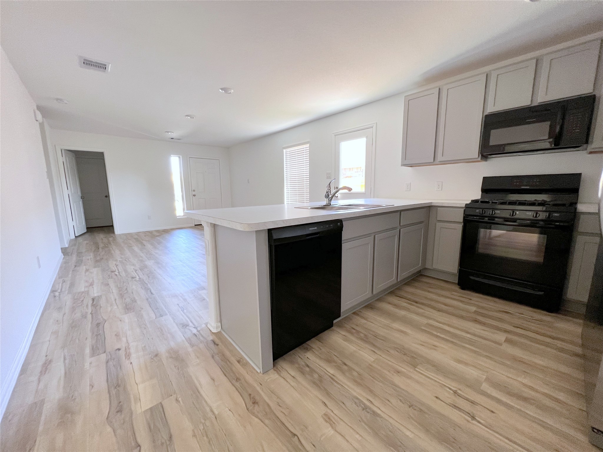14518 Woodcott Warren Way Rosharon, TX 77583 - Photo 5 of 18 a kitchen with stainless steel appliances granite countertop a stove a sink and a microwave
