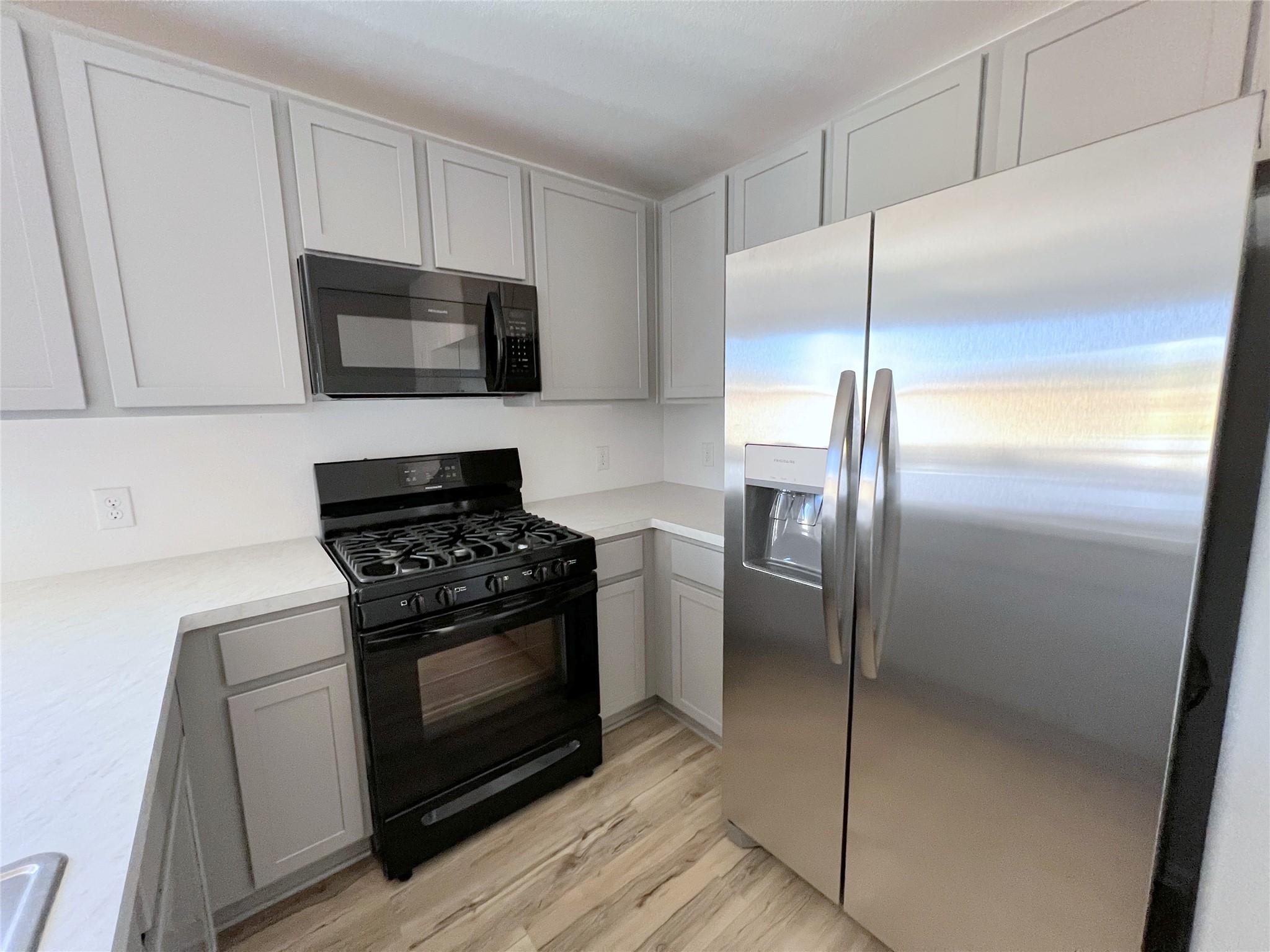 14518 Woodcott Warren Way Rosharon, TX 77583 - Photo 7 of 18 a kitchen with stainless steel appliances wooden floor sink and wooden cabinets