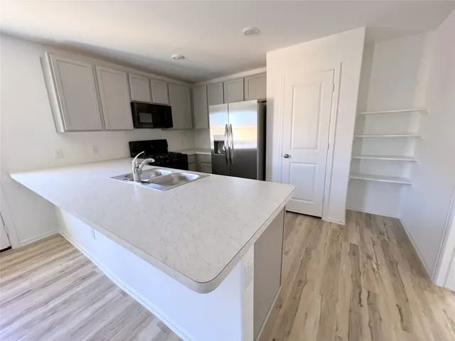 a kitchen with kitchen island a sink appliances and cabinets