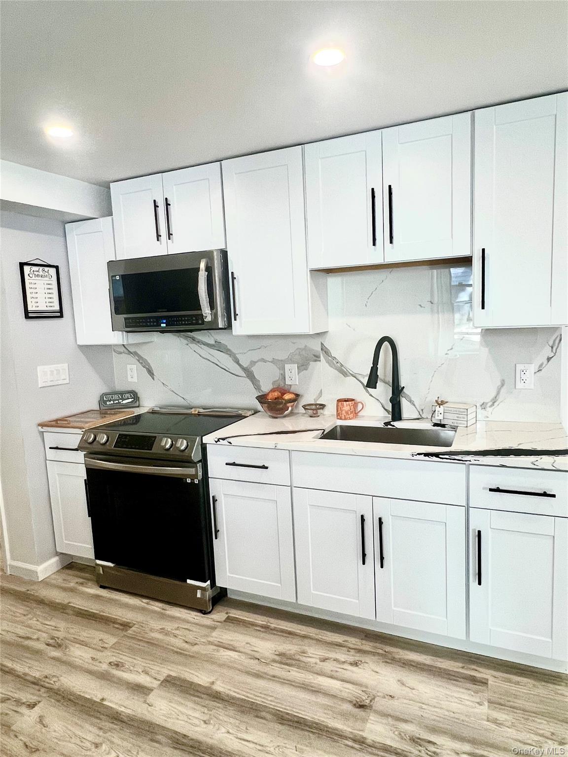 126 West Main Street, Unit 2 Middletown, NY 10940 - Photo 2 of 15 Kitchen with appliances with stainless steel finishes, white cabinetry, light wood-type flooring, and recessed lighting