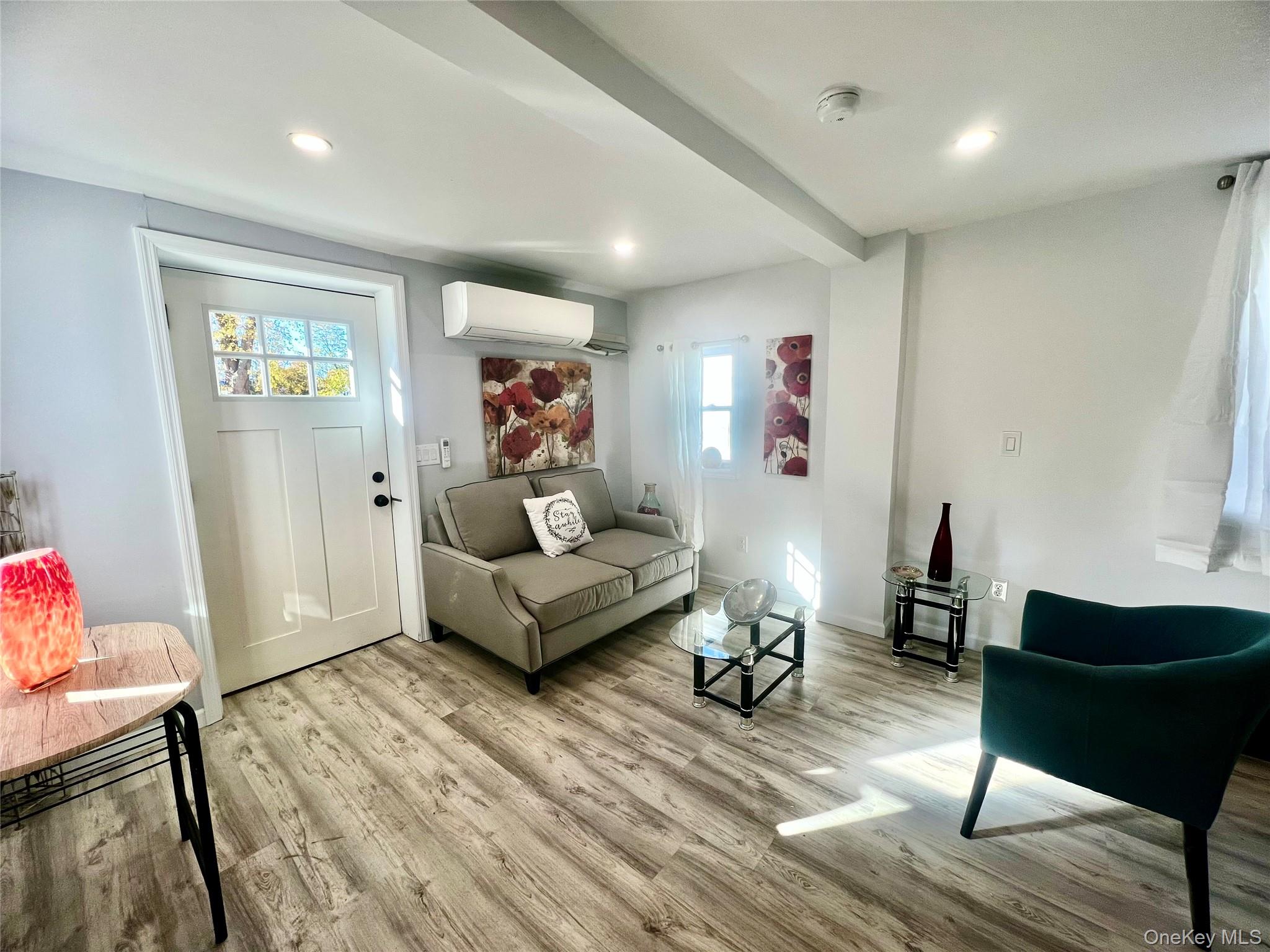 126 West Main Street, Unit 2 Middletown, NY 10940 - Photo 5 of 15 Living room with light wood-style floors, beam ceiling, recessed lighting, and an AC wall unit