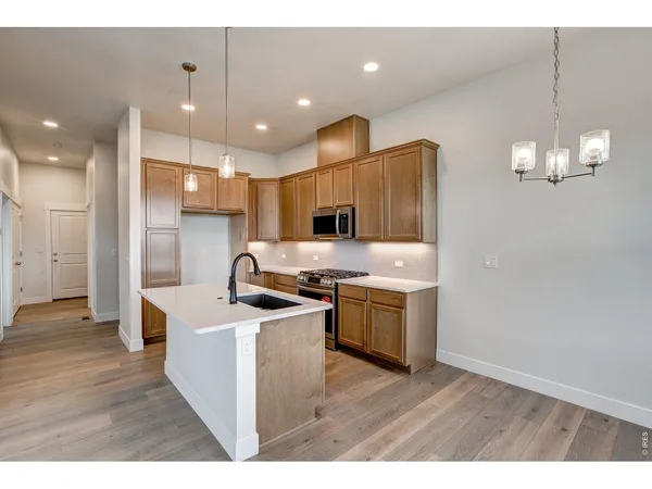 a kitchen with stainless steel appliances granite countertop a sink a stove and a refrigerator