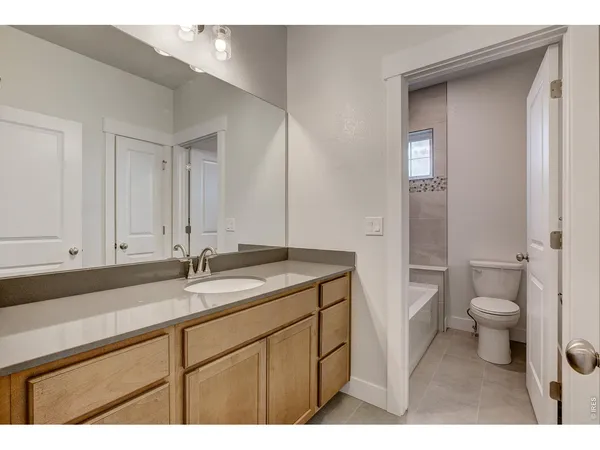 a bathroom with a sink a toilet and a large mirror