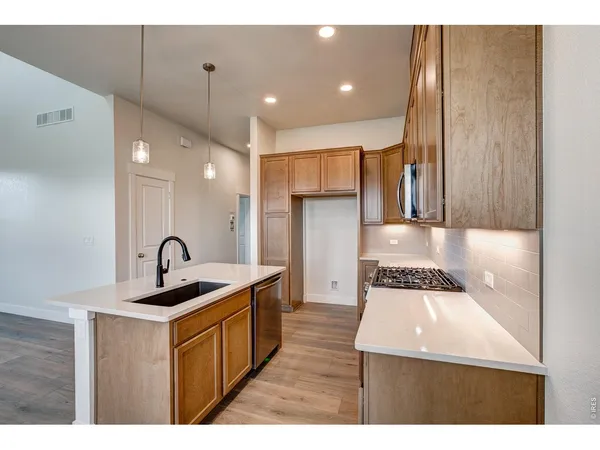 a kitchen with kitchen island stainless steel appliances a sink and cabinets