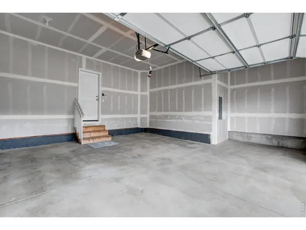 a view of an empty room with a white walls and stairs