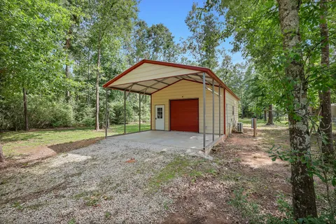 a view of a house with backyard and trees