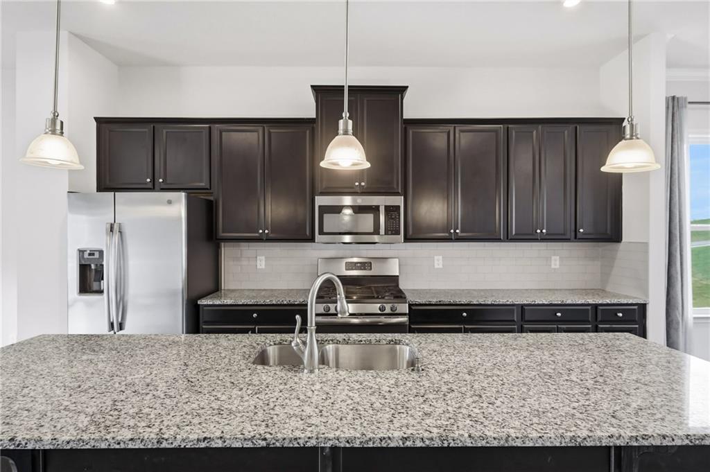 3000 Mahican Circle Mars, PA 16046 - Photo 18 of 39 a kitchen with kitchen island granite countertop a refrigerator a stove and a sink with wooden floor