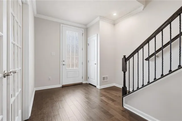 a view of a hallway with wooden floor and staircase