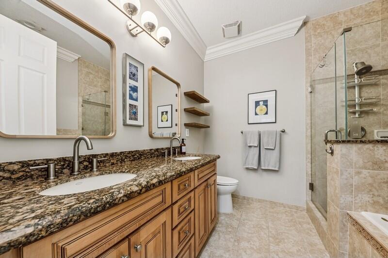 8292 Northwest 9th Avenue Boca Raton, FL 33487 - Photo 12 of 15 a bathroom with a granite countertop sink a mirror and a shower