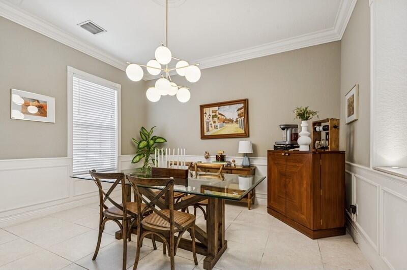 8292 Northwest 9th Avenue Boca Raton, FL 33487 - Photo 8 of 15 a dining room with furniture and a chandelier fan