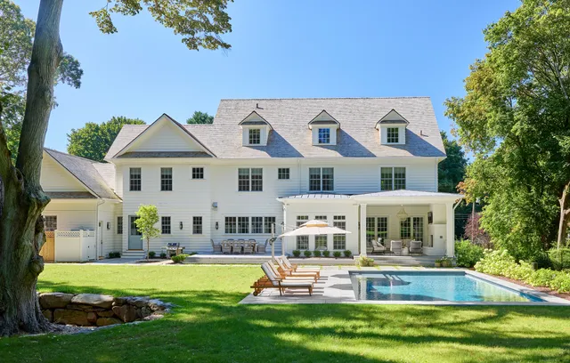 a front view of a house with swimming pool having outdoor seating