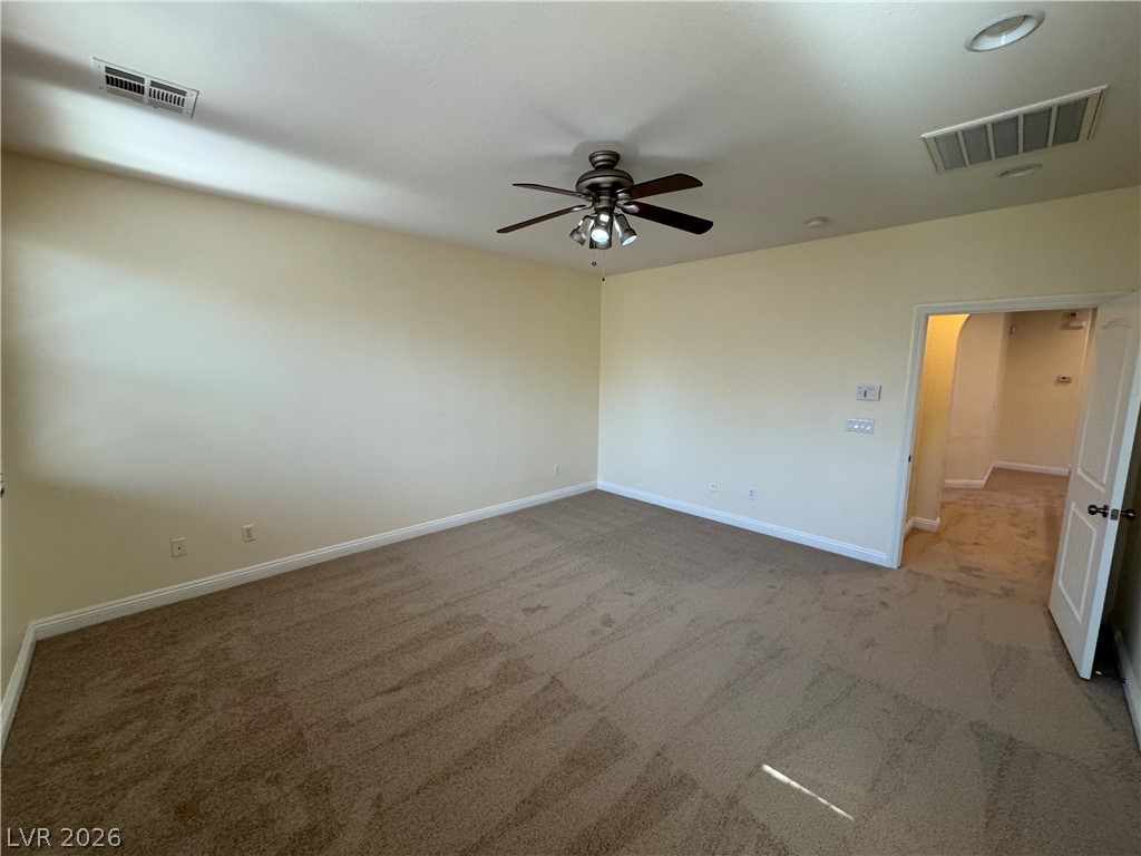 1333 Jamesbury Road Las Vegas, NV 89135 - Photo 32 of 43 A quiet bedroom with plush carpeting offers a serene escape, complemented by a ceiling fan for year-round comfort.