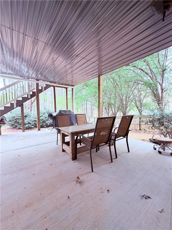 3830 Peachbluff Court Duluth, GA 30097 - Photo 33 of 39 a view of a patio with table and chairs and couches with wooden roof and stairs