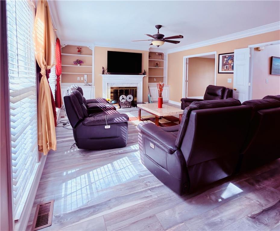 3830 Peachbluff Court Duluth, GA 30097 - Photo 9 of 39 a living room with furniture a flat screen tv and a fireplace