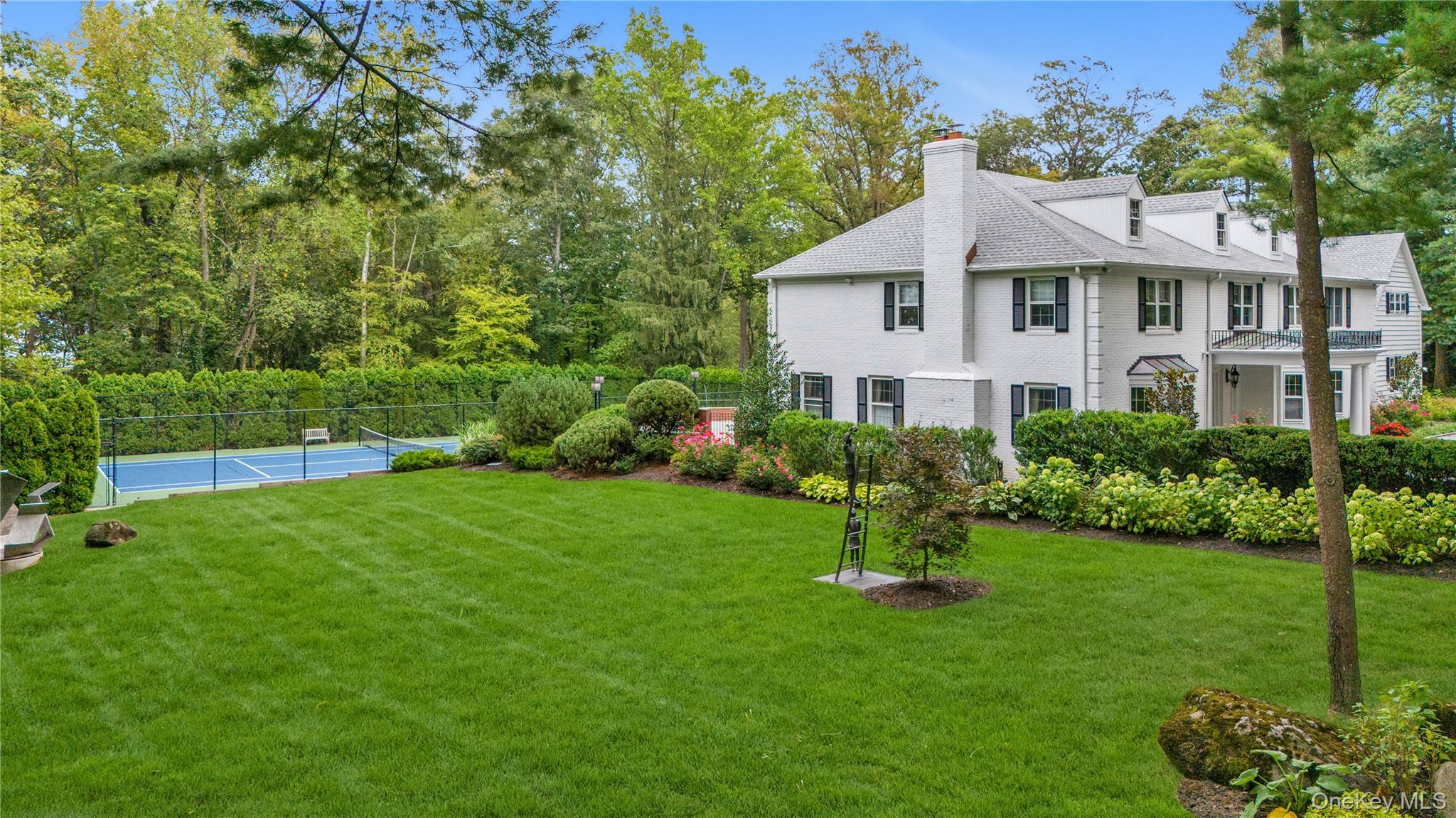 45 SE Road Sands Point, NY 11050 - Photo 22 of 36 a front view of a house with a yard and green space