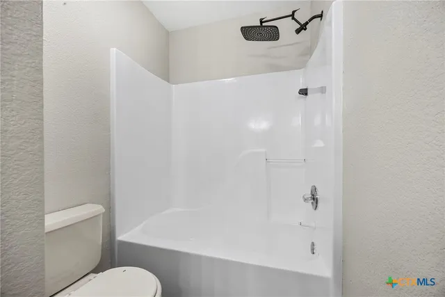 a bathroom with a shower and toilet