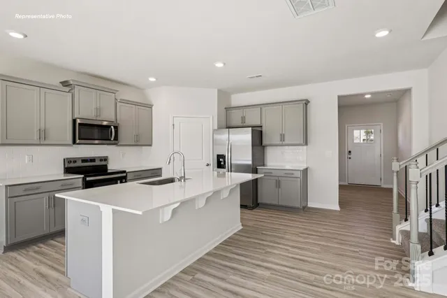 a kitchen with white cabinets stainless steel appliances and sink