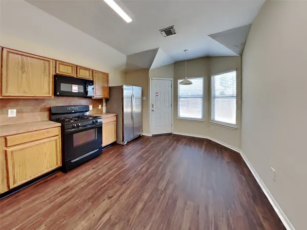 a kitchen with granite countertop wooden floors and stainless steel appliances