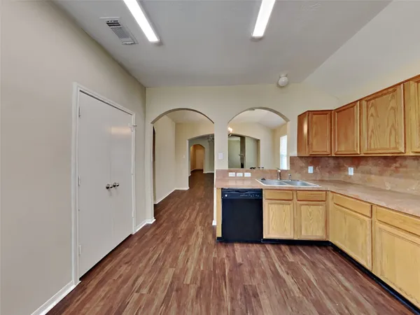 a large kitchen with wooden floors and stainless steel appliances