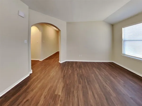 an empty room with wooden floor and a window