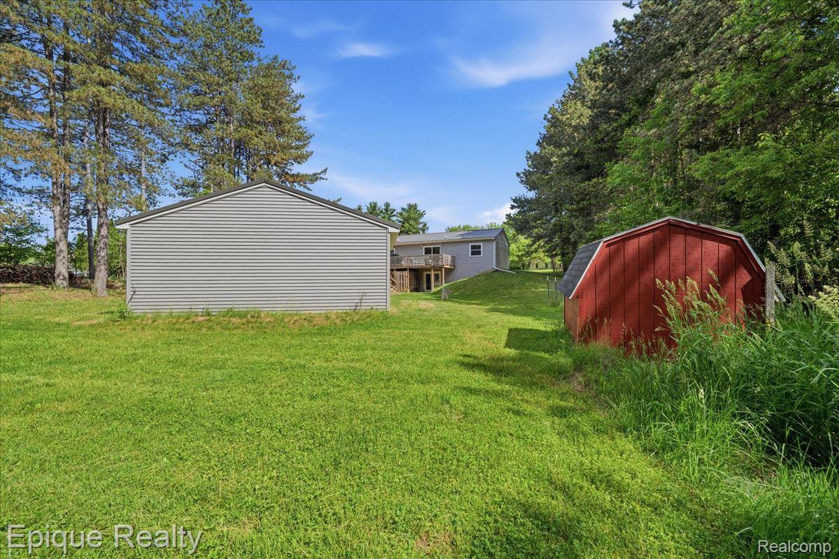 12272 East Mt Morris Road Davison, MI 48423 - Photo 34 of 39 Expansive green lawn featuring a gray siding outbuilding and a red gambrel roof shed