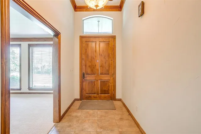 a view of an empty room with chandelier fan and a window