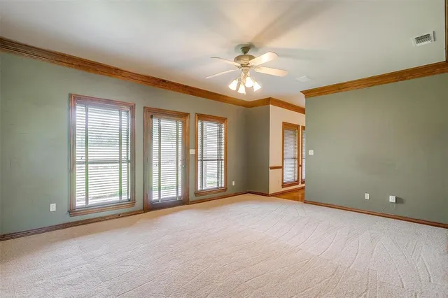 an empty room with a window and a fan