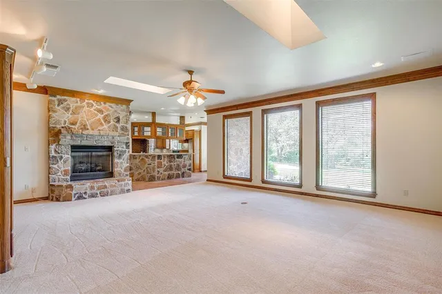 a view of an empty room with a fireplace and a window